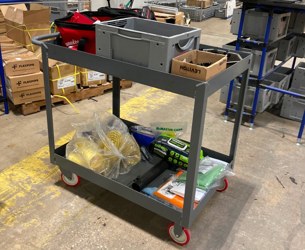 two-level, steel-welded pushcart with three-inch deep shelving to keep parts, tools, and consumables from falling off of either of the two levels.
