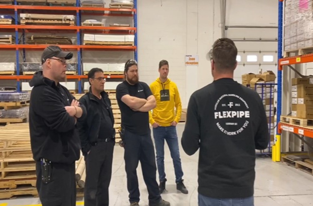 five people within a warehouse discussing an upcoming warehouse optimization Kaizen event