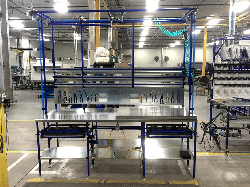 Modular workstation with tool storage, blue frame, stainless steel worktop, and tool board for electrical equipment assembly