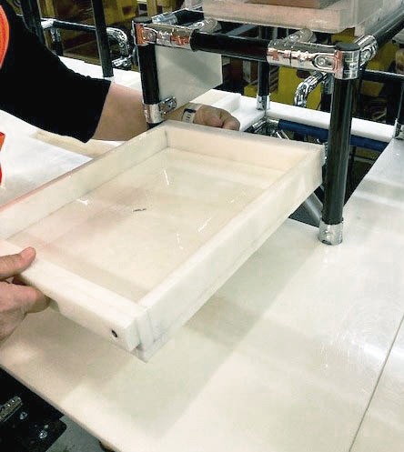 Modular workstation with integrated white drawer and black pipe frame for electrical equipment assembly