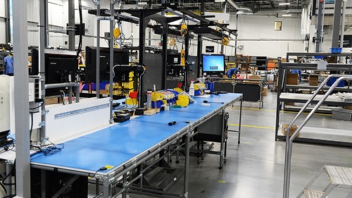 Overhead modular pipe system supporting attachments in an electrical equipment manufacturing facility.