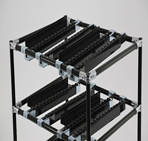 Close-up top view of a hybrid flow rack showing black Flexpipe-coated steel pipes assembled with chrome joints, supporting multiple roller tracks with guide flanges. This image highlights the FIFO functionality and modular structure used for lean material handling applications.