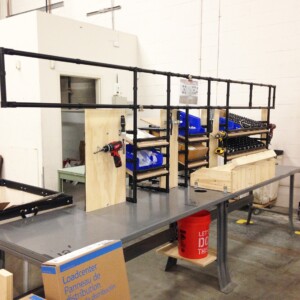 Final assembly workstation for electric panels with modular shelving and square pipe frame for 5S and lean manufacturing