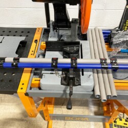 Pipe cutting station with modular clamp system featuring square pipes and precise mounting for lean manufacturing setups